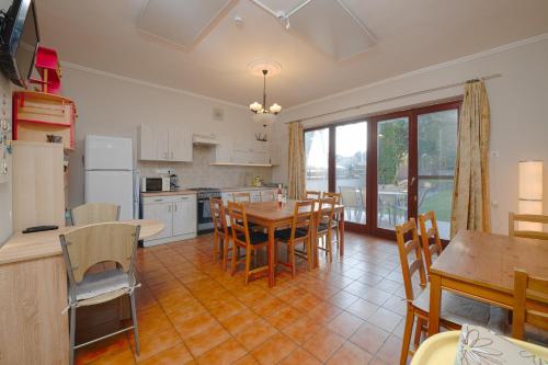 a kitchen and dining room with a table and chairs at Valley Vendégház in Eger