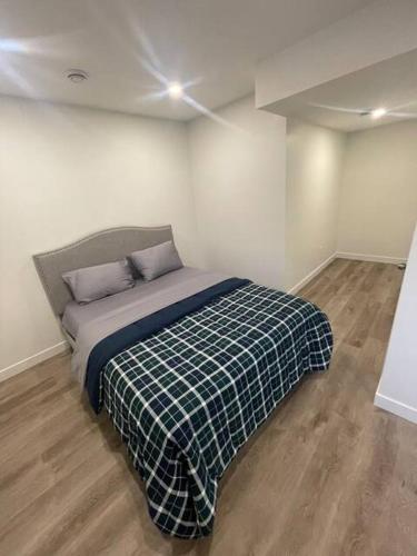 a bedroom with a bed with a plaid blanket at Bedroom in Southwest D in Edmonton