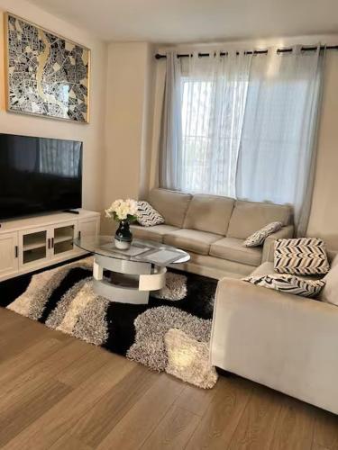 a living room with a couch and a tv at Bedroom in Southwest D in Edmonton