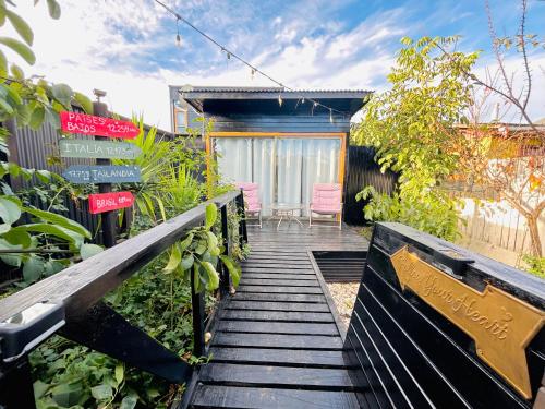 a wooden walkway leading to a garden with a house at Mini Refugios Lodge in Constitución