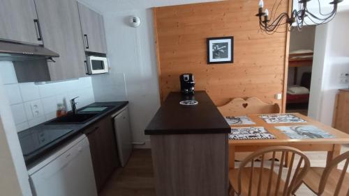 - une petite cuisine avec un comptoir et une table dans l'établissement Appartement 2 chambres au pied des pistes de l'espace Diamant, à Flumet