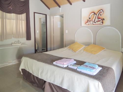 a bedroom with a bed with two towels on it at Pousada Juriti - Eco Hotel in São Roque