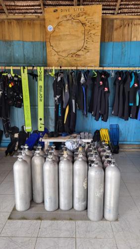 a bunch of silver tanks lined up against a wall at Pristine Paradise Dive Resort - Togean Islands, Una Una in Pulau Unauna