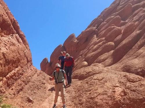 a group of people walking through a canyon at Ait Sedrate Tourism Cooperative Hotel in Boumalne