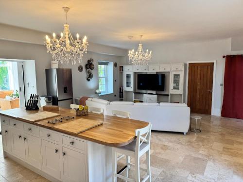 a kitchen and living room with a table and a couch at Stunning and luxurious Manor House holiday home in Broadmayne