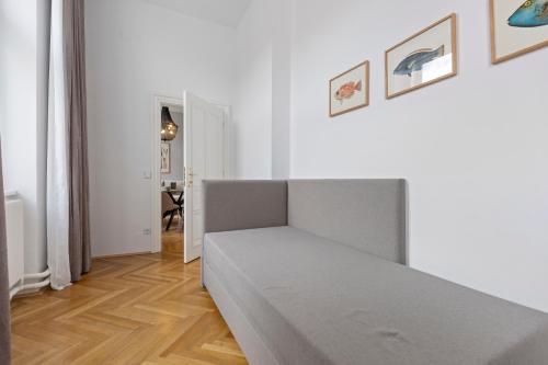 a white room with a bed and a wooden floor at sgrafit apartments - Self Check-In in Retz