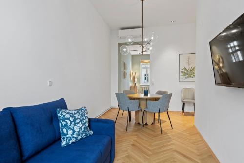 a living room with a blue couch and a table at sgrafit apartments - Self Check-In in Retz