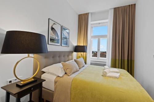 a bedroom with a bed with a lamp and a window at sgrafit apartments - Self Check-In in Retz
