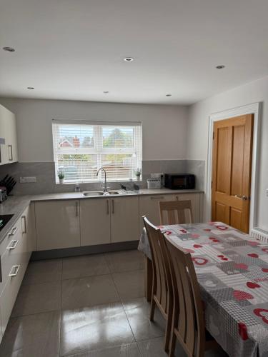 a kitchen with a table and a sink and a table and chairs at The Clara, Ballycastle in Ballycastle