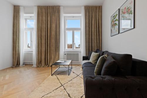 a living room with a couch and two windows at sgrafit apartments - Self Check-In in Retz