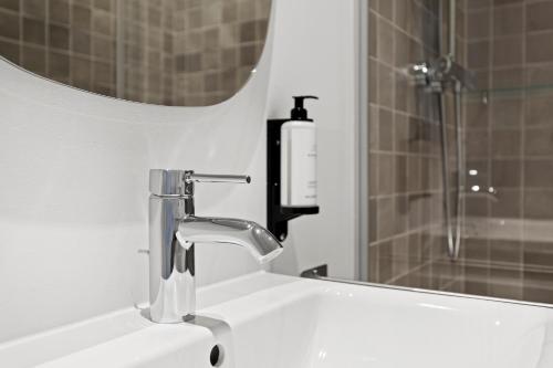 a bathroom sink with a faucet and a mirror at sgrafit apartments - Self Check-In in Retz