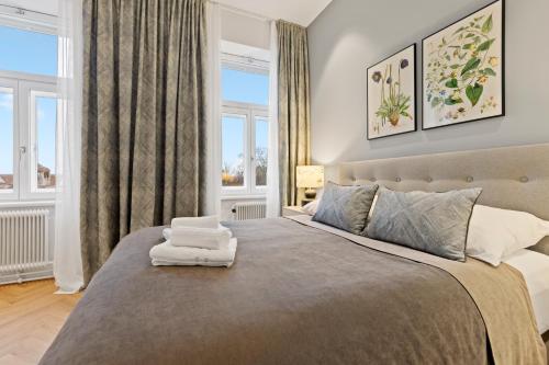 a bedroom with a large bed and two windows at sgrafit apartments - Self Check-In in Retz