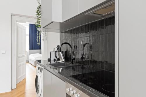 a kitchen with a sink and a stove at sgrafit apartments - Self Check-In in Retz