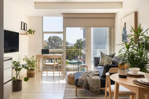 a living room with a couch and a table with plants at The Braemar - Cape 8 Collection in Cape Town