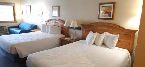 a hotel room with two beds and a blue chair at Homestead Suites - Fish Creek in Fish Creek