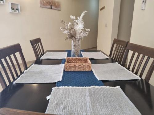 a dining room table with chairs and a vase with flowers at Cassia Seaview Retreat in Chlorakas