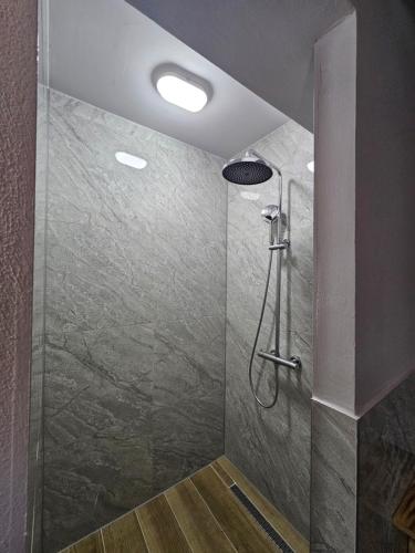 a bathroom with a shower with a shower head at Hani i Ilirit in Cërrik