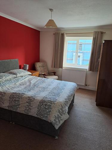 a bedroom with a bed and a chair and a window at 94 Main Street - Pembroke Holiday Home in Pembroke
