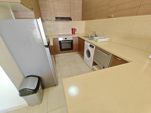 a small kitchen with a refrigerator and a dishwasher at Cassia Seaview Retreat in Chlorakas