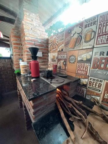 a counter in a room with a wall of beer signs at Estância arco iris in Regente Feijó