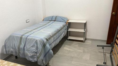 a small bedroom with a bed and a night stand at Bedroom 20 minutes from Sevilha Alcalá de Guadaíra in Alcalá de Guadaira