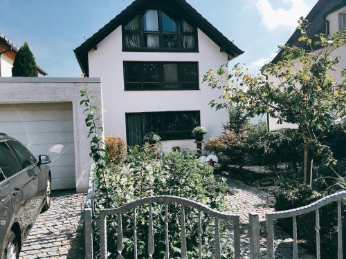 a white house with a fence in front of it at Ferienwohnung Stadthaus Cham in Cham