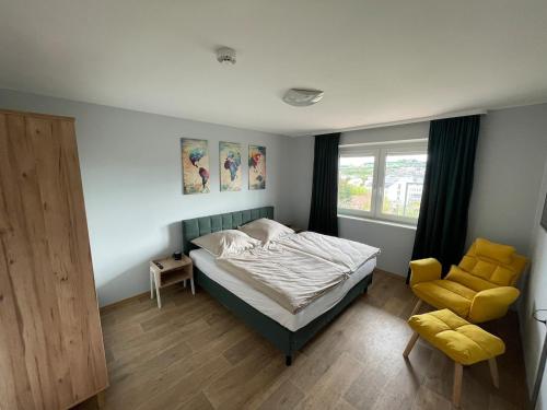a bedroom with a bed and a chair and a window at Ferienwohnung Stadthaus Cham in Cham
