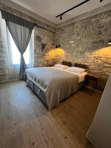 a bedroom with a bed and a stone wall at NisUrla in Urla