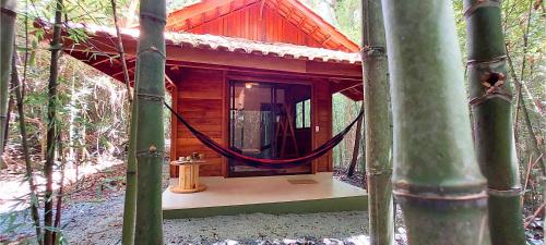 a log cabin with a fire hydrant in the woods at Cabana de madeira entre as árvores in Piedade
