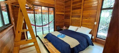 a bedroom with a bed in a log cabin at Cabana de madeira entre as árvores in Piedade