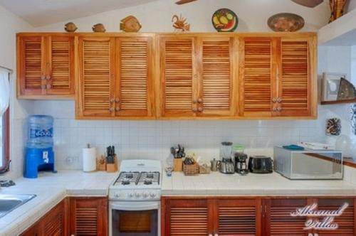 a kitchen with wooden cabinets and a stove top oven at Beachfront Hammock Heaven in Akumal