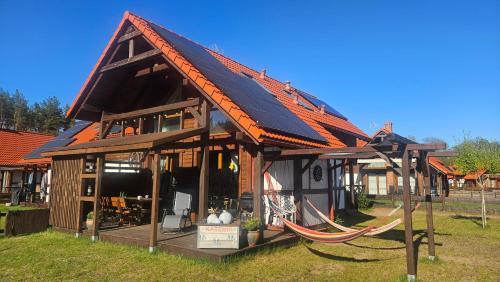 a small house with an orange roof with a swing at Ostoja Bukowo Kaszmir 18,1 in Borowy Młyn