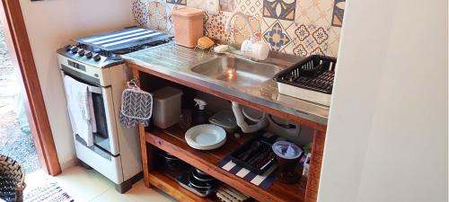 a small kitchen with a sink and a stove at Cabana de madeira entre as árvores in Piedade