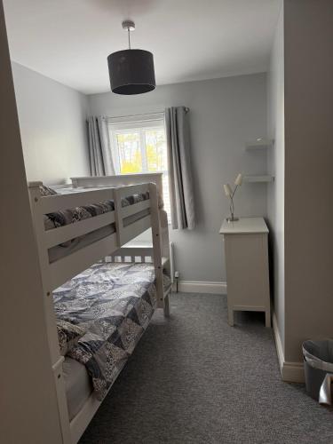 a bedroom with a bunk bed and a window at The Clara, Ballycastle in Ballycastle