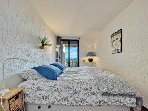 une chambre avec un lit avec des oreillers bleus dans l'établissement La Brigantine- Golfe de St Tropez, à Cogolin