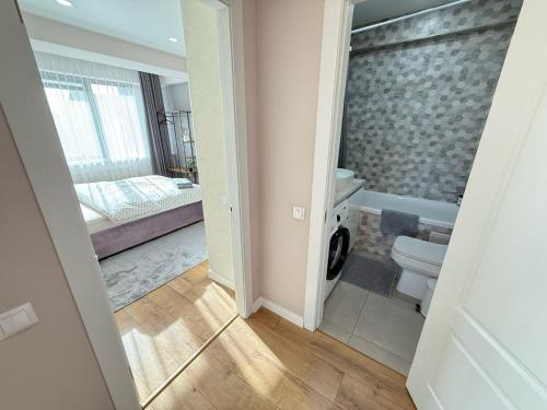 a bathroom with a toilet and a bed in a room at RentNow Large and Cozy Apartment in the Center, Parking in Chişinău