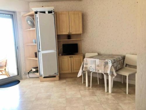 une cuisine avec une table et un réfrigérateur dans l'établissement Résidence Ngu-81-pornichet - pornichet studio vue mer MAE-6561, à Pornichet