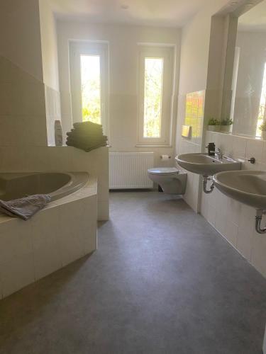 a bathroom with two sinks and a tub and a toilet at Heisenberg 4 Personen Familienfreundlich in Markranstädt