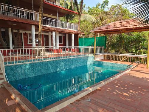 a swimming pool in front of a house at The Mango Valley Nature's Stay in Alibag