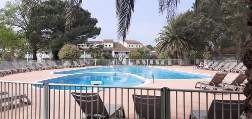 une piscine avec des chaises et une clôture dans l'établissement Appartement cosy, à Moliets-et-Maa