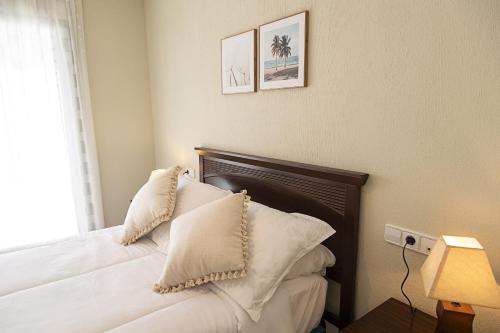 a bedroom with a bed with white pillows at Costa Azul 5 L in La Manga del Mar Menor
