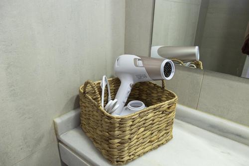 a hair dryer in a basket next to a mirror at Costa Azul 5 L in La Manga del Mar Menor