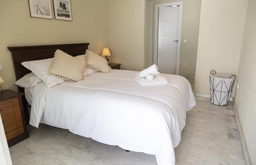 a bedroom with a large bed with white sheets at Costa Azul 5 L in La Manga del Mar Menor