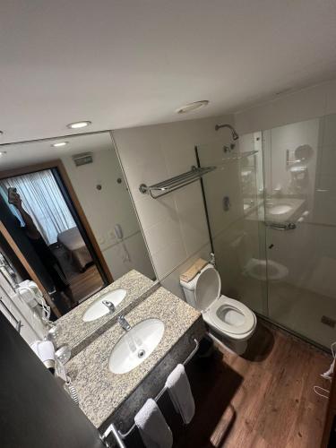 a bathroom with two sinks and a shower and a toilet at Flat na Barra da Tijuca - Premium - Com Cozinha, Microondas, Estacionamento, Balsa para Praia, Academia, Muito lindo, Confortável e Aconchegante in Rio de Janeiro