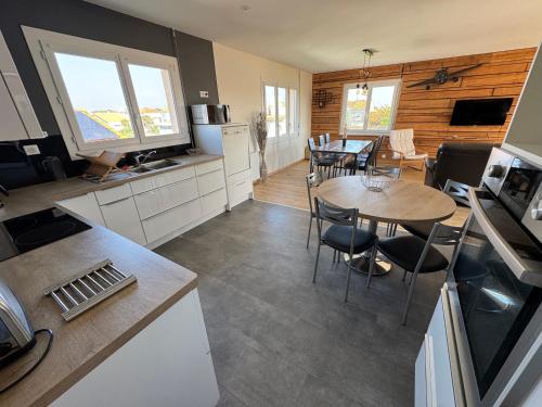 une cuisine et un salon avec une table et des chaises dans l'établissement Logement 6 couchages, 3 chambres , jardin , parking , fibre wifi, à Les Sables-dʼOlonne