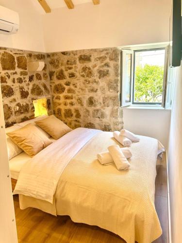 a bedroom with a large bed with towels on it at Little House Komiza in Komiža