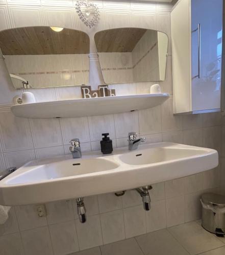 a bathroom with a white sink and a mirror at Edelweiss Chalet in Uttendorf