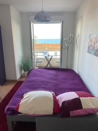 - un lit violet avec deux oreillers dans une chambre dans l'établissement Comfy 2 min to Beach - AC, à Nice