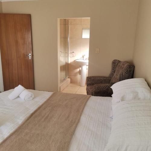 a bedroom with a bed and a bathroom with a shower at The WhiteHouse FarmHouse Overnight Stay in Ritchie