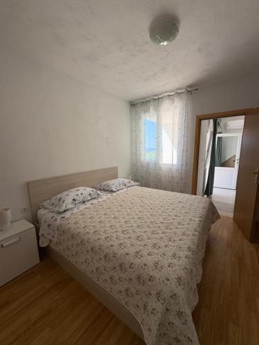 a bedroom with a bed and a window at Apartmani Lešić Zaklopatica in Lastovo